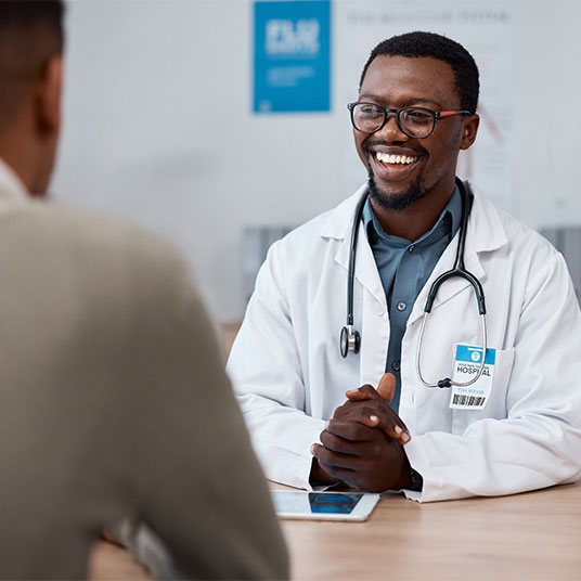 A doctor sitting with a patient.